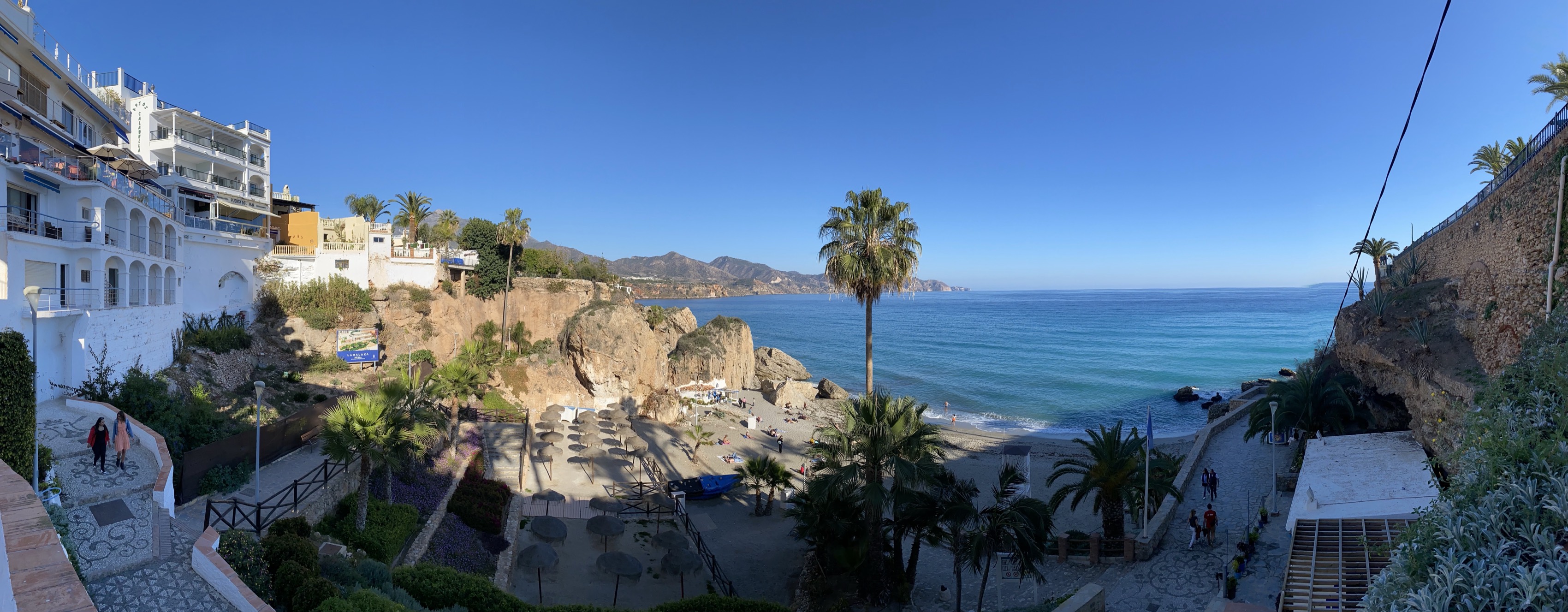 A panoramic view across a sunny Mediterranean cove in Nerja